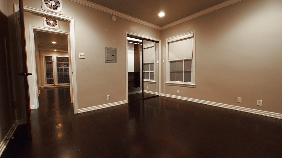 The bedroom looking toward the door and mirrored closet